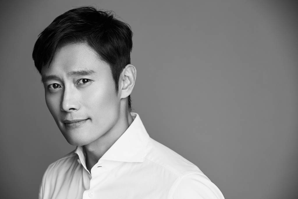 회색 배경 앞에서 흰 셔츠를 입고 카메라를 바라보는 이병헌의 공식 프로필